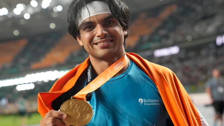 Neeraj Chopra dons India’s colors and displays his gold medal after winning the men’s javelin throw at the Asian Games.